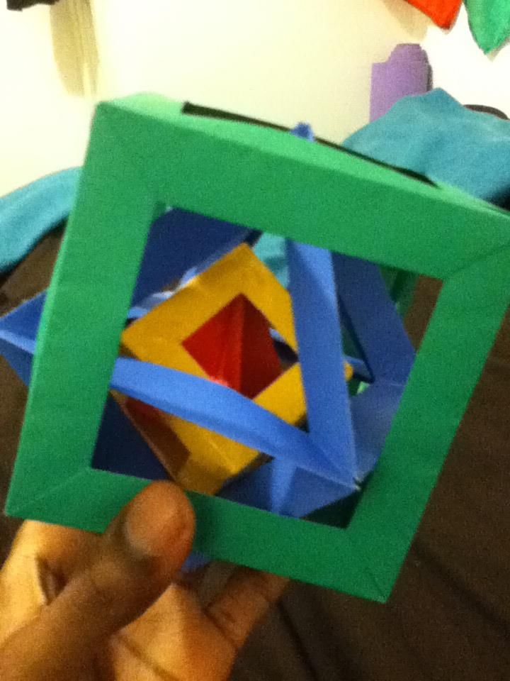 A modular origami cube of nested open frames in green, blue and yellow